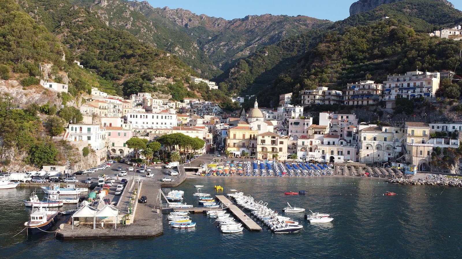 Porticciolo di Cetara con barche ormeggiate, spiaggia e case colorate ai piedi dei monti