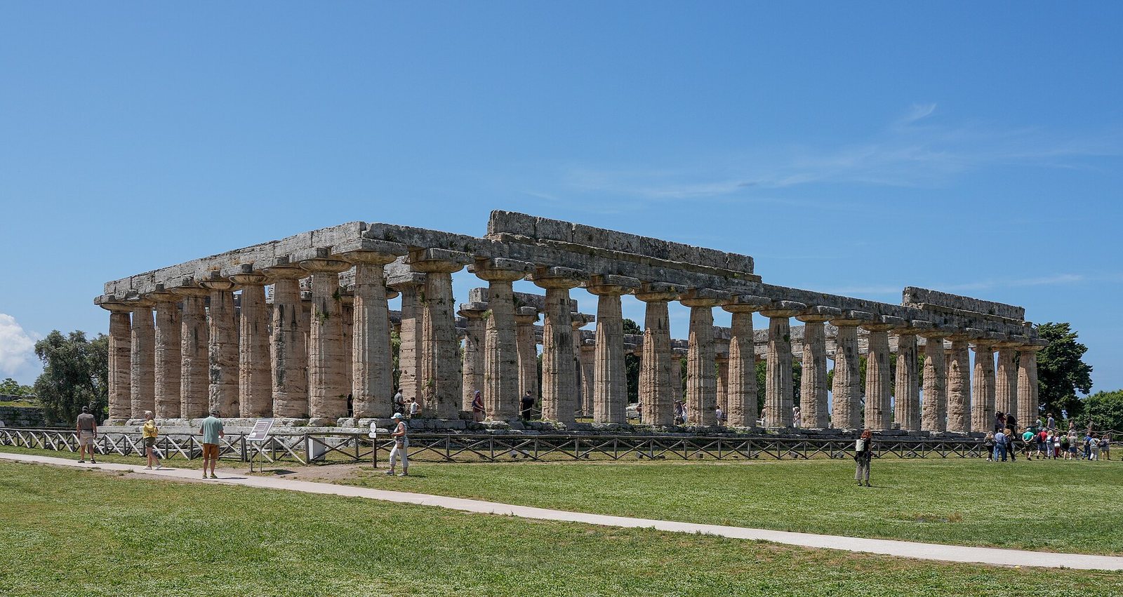 Colonnato dorico del Tempio di Hera nel parco archeologico di Paestum su un prato verde